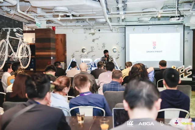 A packed room at the Hong Kong demo day, with the Spawn Point title slide on the screen.